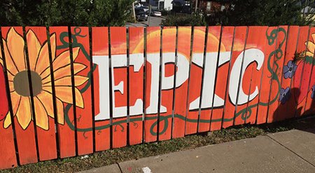 Community mural painted in bright colors on a fence