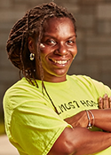 Erika Cooper wears a yellow shirt and stands outside