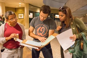 Three Students looking at a folder