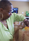 Mary Jones looks at bags of groceries being offered to the community