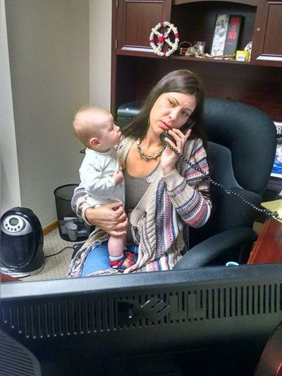 Chrystel Cornelius takes a conference call while holding Langholz's new baby.