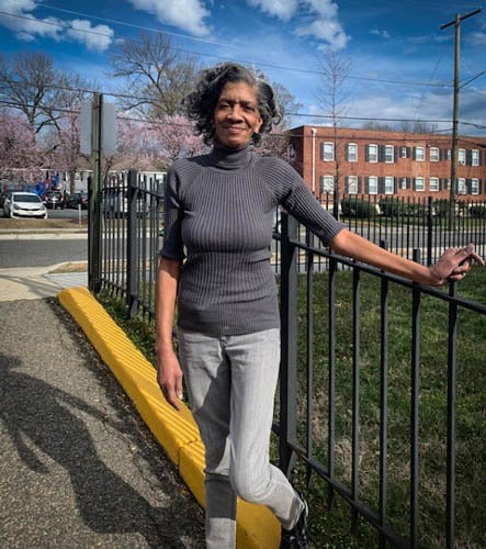 Evelyn Harrison, a Black woman and community leader, stands outside in the neighborhood that she helped save