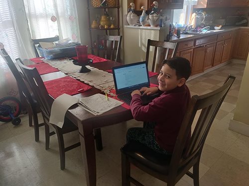 Diego Portillo works on his school work at the dining room table.