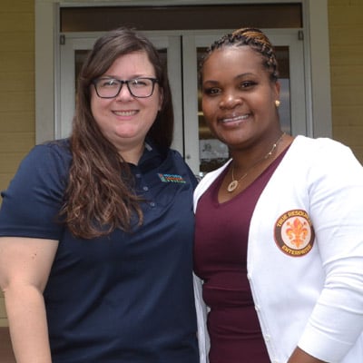 Providence Community Housing's resident services coordinator stands with a New Orleans resident before COVID-19