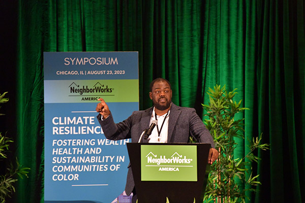 Symposium speaker stands at a podium at NeighborWorks America's climate resilience symposium in Chicago, Illinois