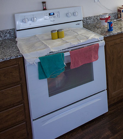 A stove with a pink and green dishcloth