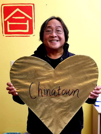 Rev. Norman Fong holding up a sign that says "Chinatown."