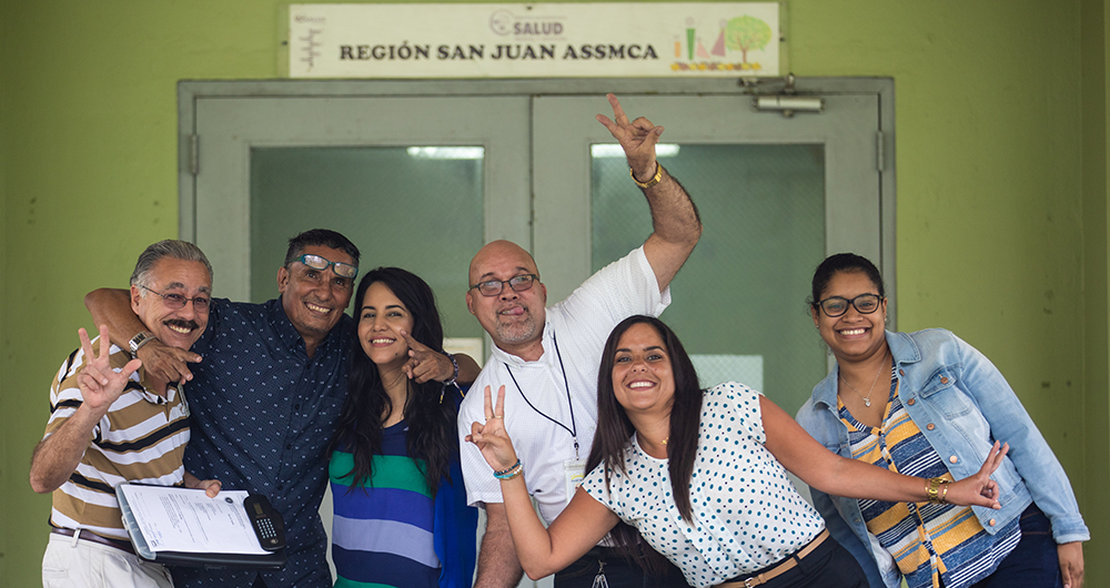 Robert Morales posing with teenagers from his program