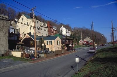 Rural town shows a long road with houses on the side.