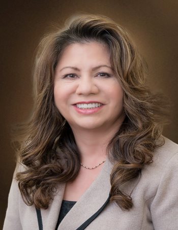 Maria Garciaz smiles, wearing a brown blazer..