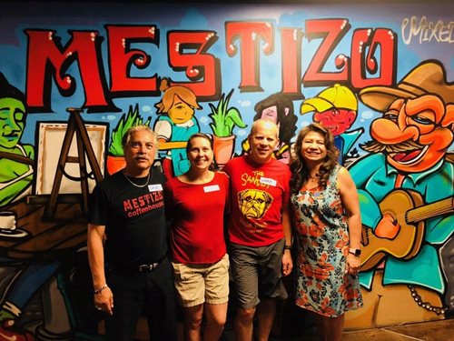 More staff members in front of a colorful background.