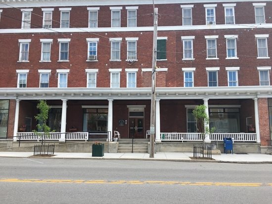 A photo of Lee House, a red, brick building that stands several stories, with white pillars in front.