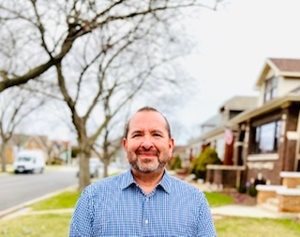 Paul Lopez, standing outside under trees.