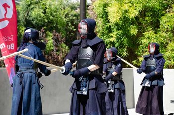 A sword demonstration from the grand opening shows a team dressed in black.