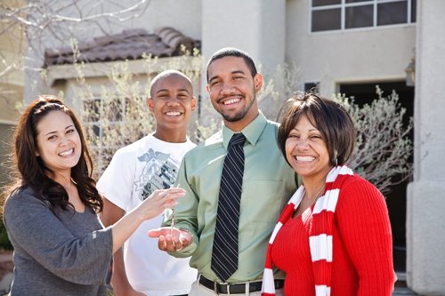 A family holds up keys to a new home.