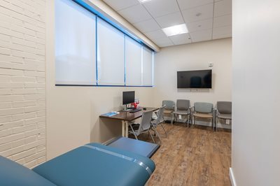 An examining room inside the health suite with a blue examining table.