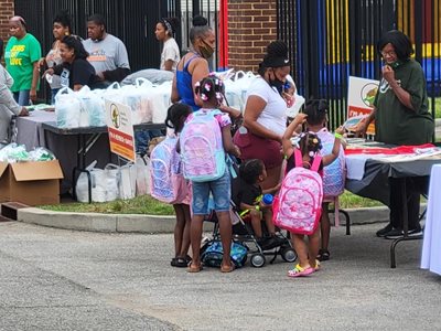 Two young girls sport their new backpacks.