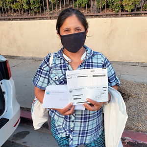 A resident poses with the rental check she used to help pay back rent.