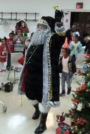 Santa rings a bell as children watch.