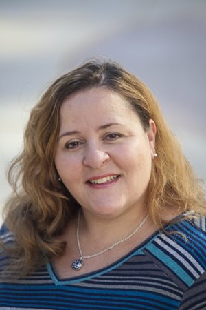 Theresa Padovano smiles in a striped shirt.