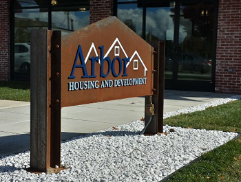 Arbor Housing and Development sign in front of a brick building