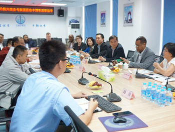 A large group of Asian men and women sit around a table