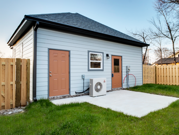 A tiny home in Tennessee with blue siding an a peach door