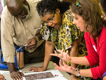 A black woman, a black man, and a white woman stand around development plans for east Raleigh, North Carolina