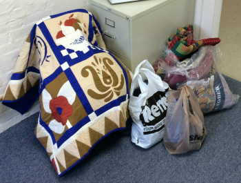 Bags of blankets sitting on the floor of an office.