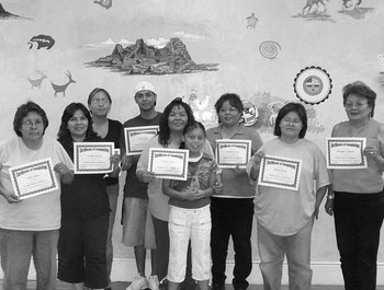 A group of Native Americans hold up their homeownership certificates