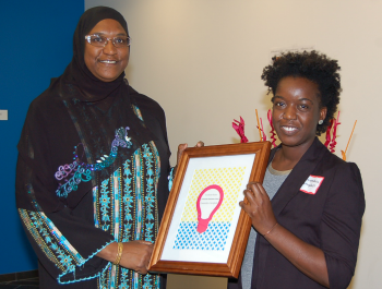 Two women holding a framed award.