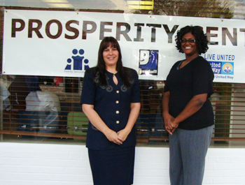 A white woman and a black woman stand in front of the Prosperity Center building