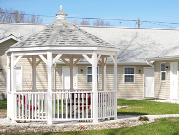 A white gazebo in the center of a one-story apartment complex