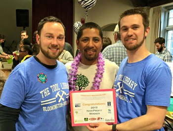 Three young men holding an award certificate for the library toolkit project