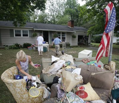 A white family in West Virginia carry furniture into their home